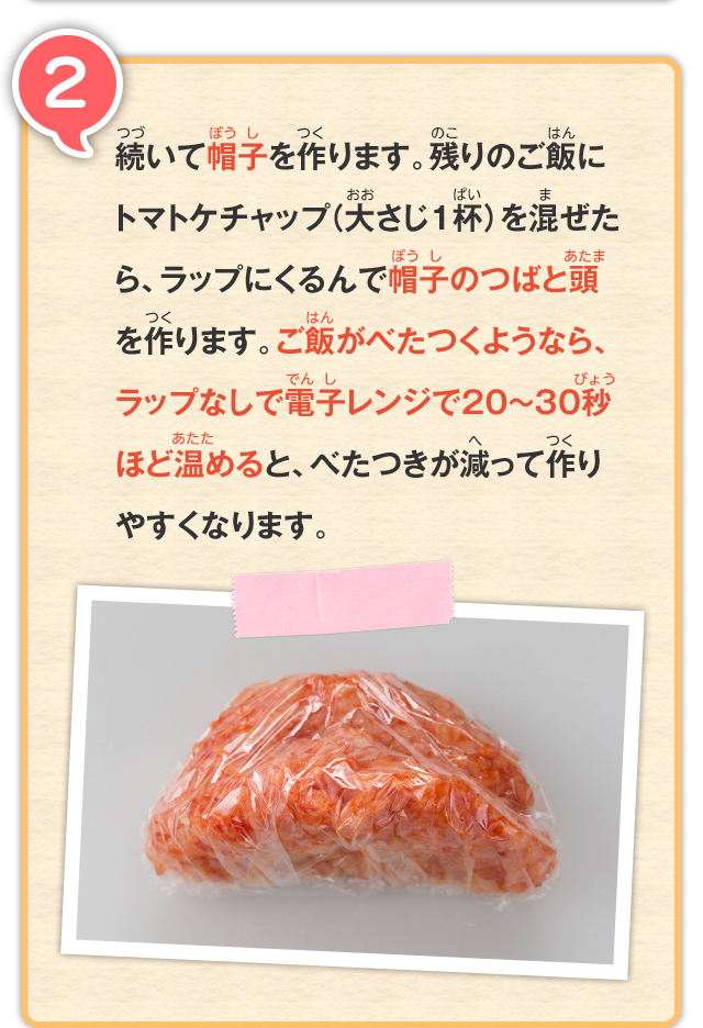 2 続いて帽子を作ります。残りのご飯にトマトケチャップ（大さじ1杯）を混ぜたら、ラップにくるんで帽子のつばと頭を作ります。ご飯がべたつくようなら、ラップなしで電子レンジで20～30秒ほど温めると、べたつきが減って作りやすくなります。